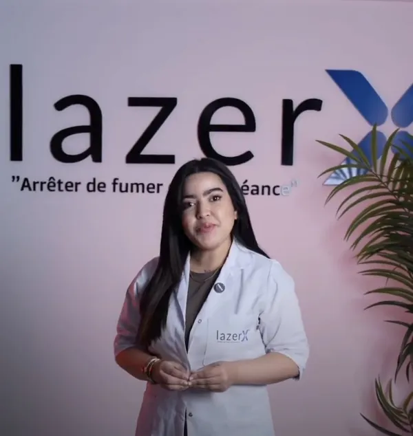 Kawtar, praticienne du centre lazerX, en blouse devant le logo